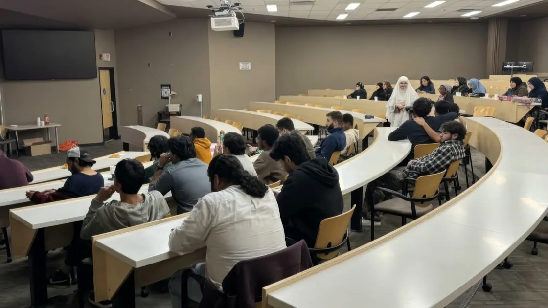 Students filling a University of Regina lecture hall, a Kahoot quiz on the screen.